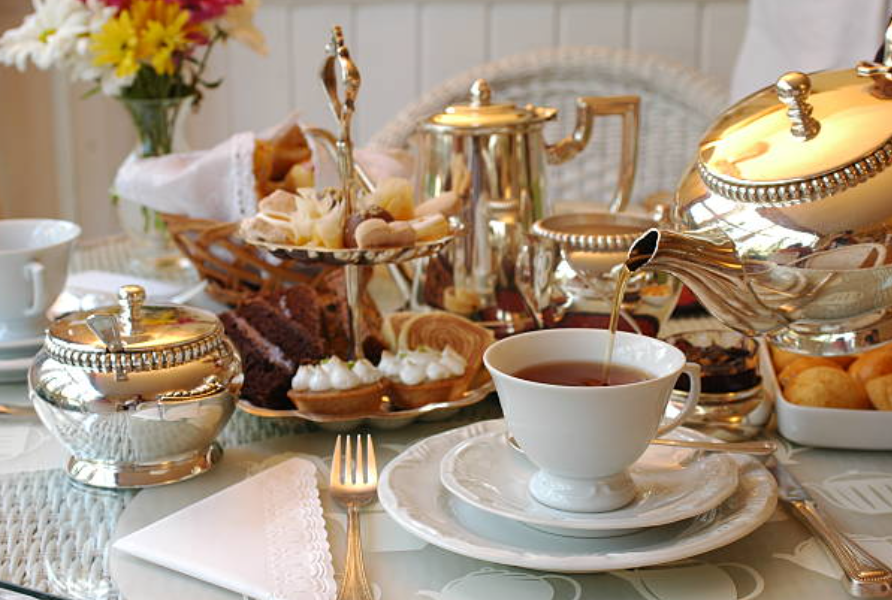 royal tea setting on a table with golden and white utensils