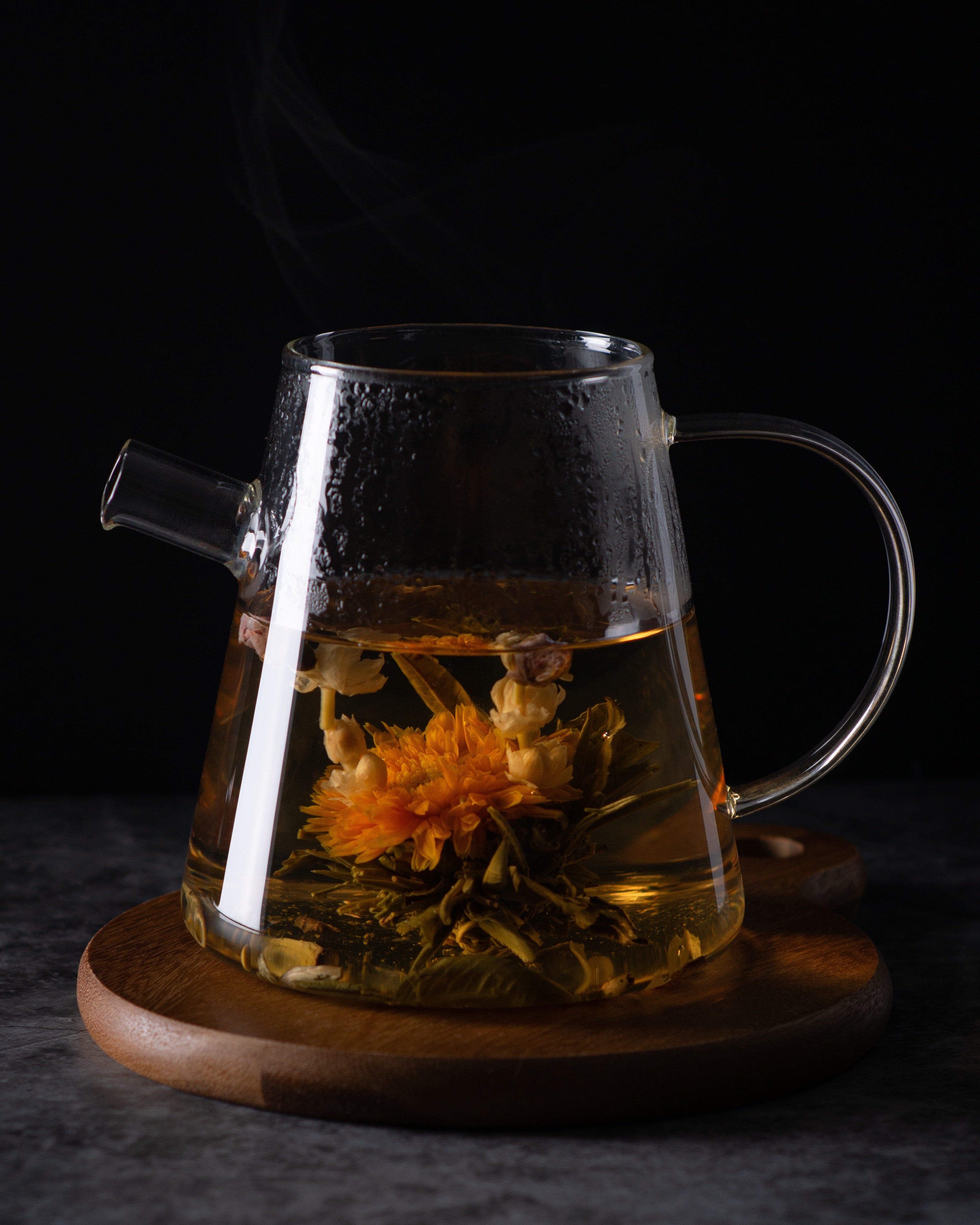 clear glass tea kettle with sunflower infused tea